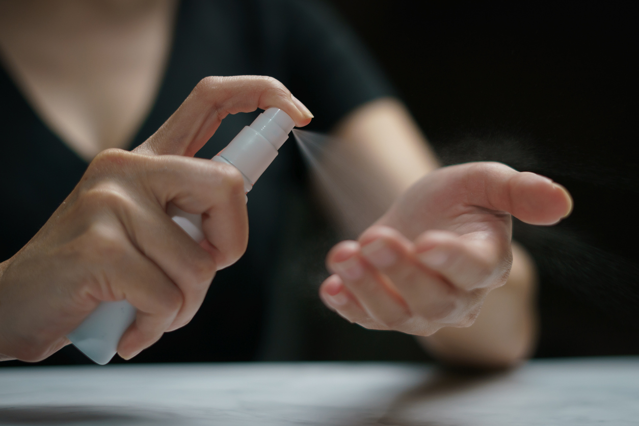 Hand applying alcohol spray for corona virus or Covid-19 protection.